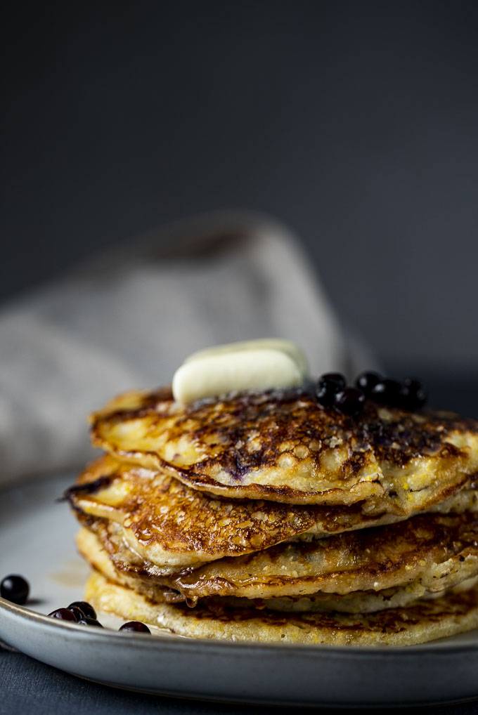 stack of blueberry pancakes with butter and syrup