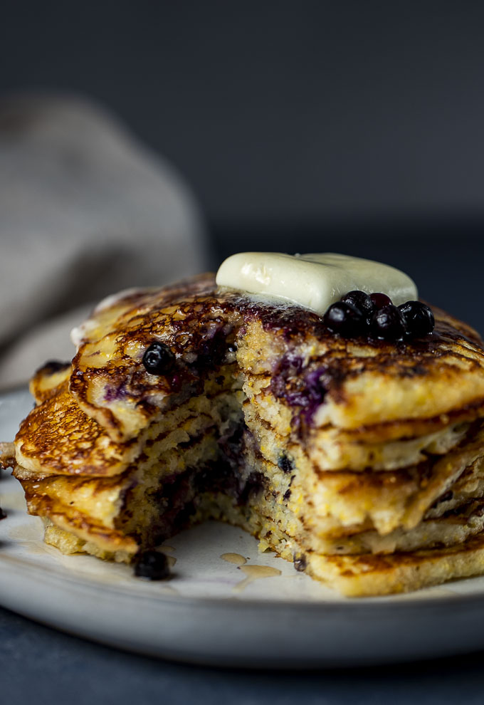 stack of pancakes cut open with butter and blueberries on top