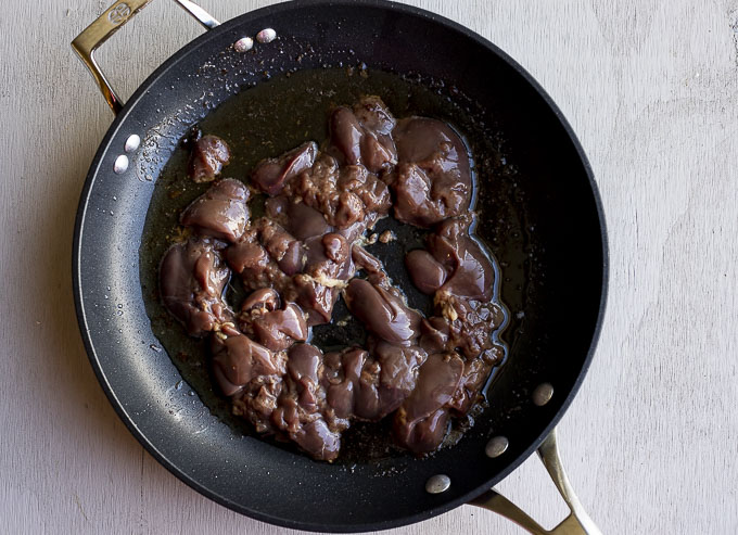 raw chicken livers in a skillet