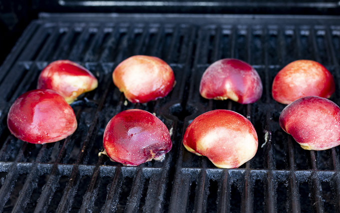 halved peaches being grilled