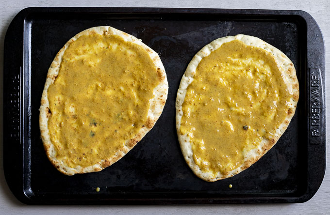 2 pieces naan bread covered in yellow sauce
