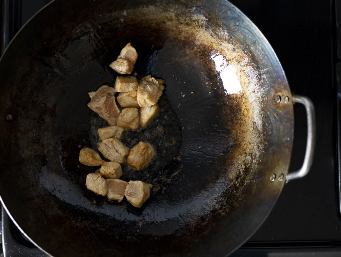 raw chicken cooking in a wok