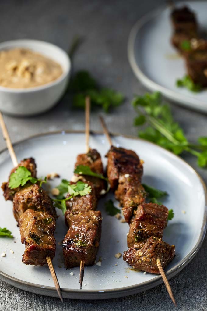 3 grilled beef skewers with peanut sauce and cilantro