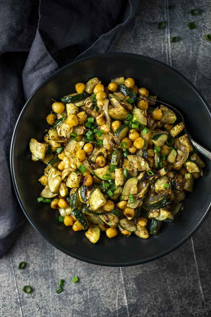bowl of roasted zucchini and chickpeas garnished with green onions