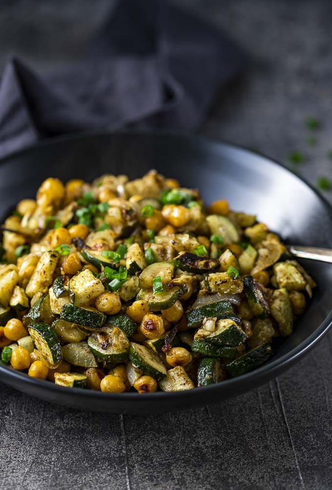 chickpea and zucchini salad in a bowl with a spoon