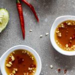 2 bowls of vietnamese dipping sauce with chilies and garlic