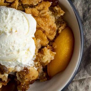 bowl of peach cobbler with ice cream on top - close up photo