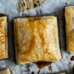 pastry drizzled in caramel on parchment paper