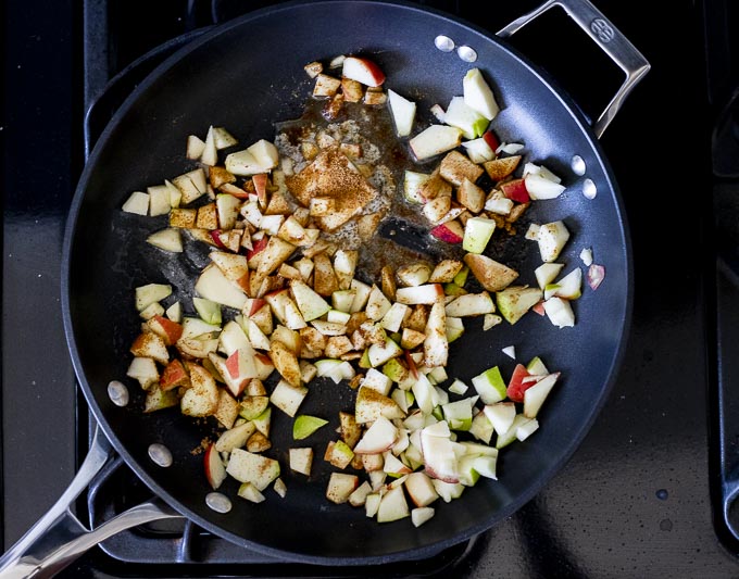 raw diced apples in a skillet with butter and sugar