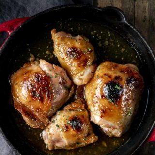 cooked chicken thighs in a skillet with glaze