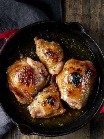 cooked chicken thighs in a skillet with glaze