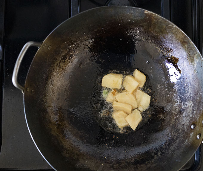 calamari pieces frying in a wok