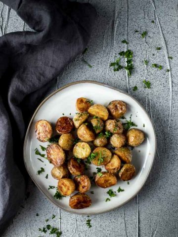 roasted mini potatoes on a plate garnished with parsley