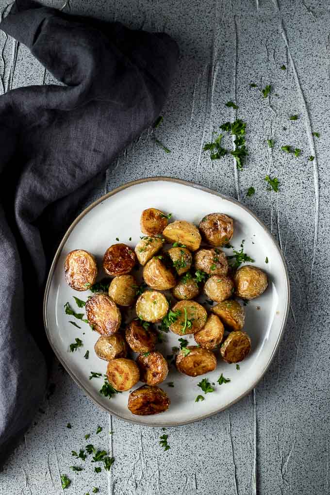 roasted mini potatoes on a plate garnished with parsley