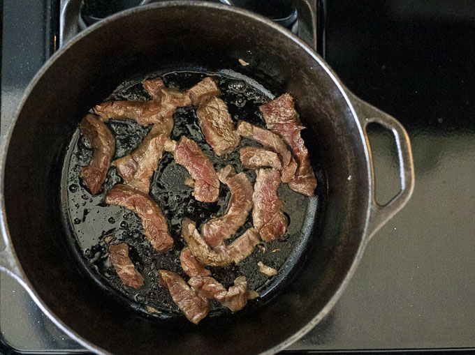 beef strips frying in a dutch oven