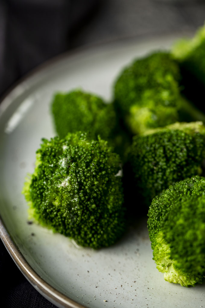 broccoli drizzled in butter on a plate
