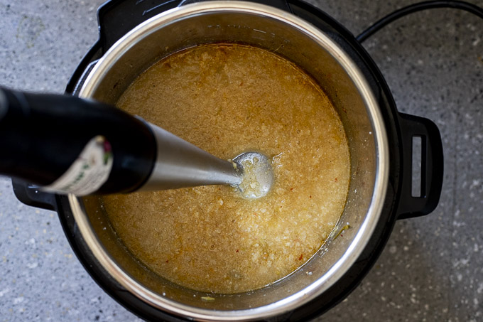 soup being blended with a hand blender in a pot