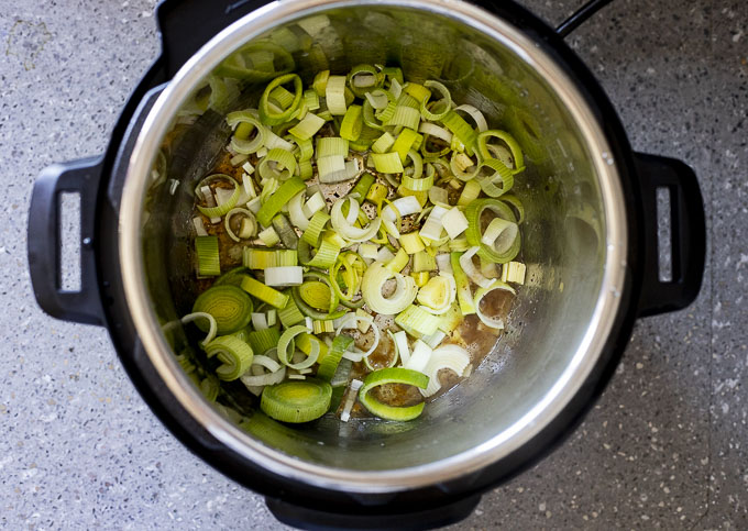 sliced leeks sauteing in a pot