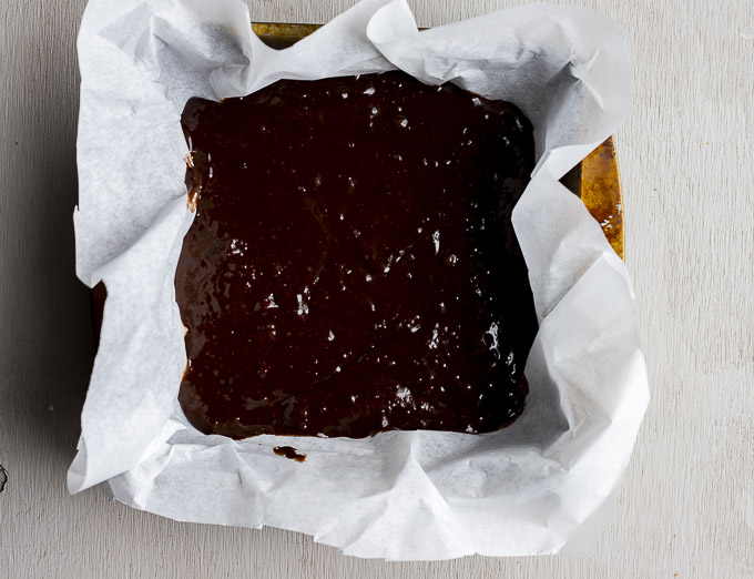 brownie batter in a parchment paper line pan