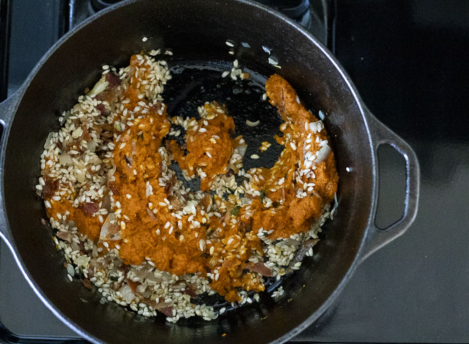 rice, bacon and pumpkin puree in a pot