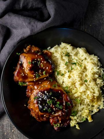 chicken thighs in a bowl with yellow rice