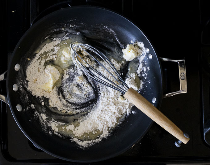 butter and flour being whisked in a skillet