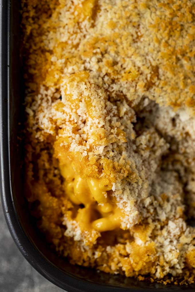 a large spoon of macaroni and cheese covered in toasted breadcrumbs