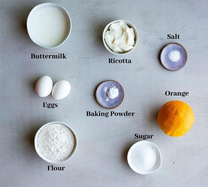 ingredients for orange ricotta pancakes on a surface