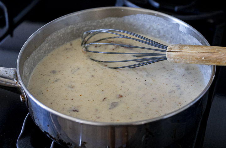 white gravy being whisked in a skillet