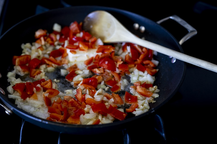 onions and red peppers cooking in a skillet