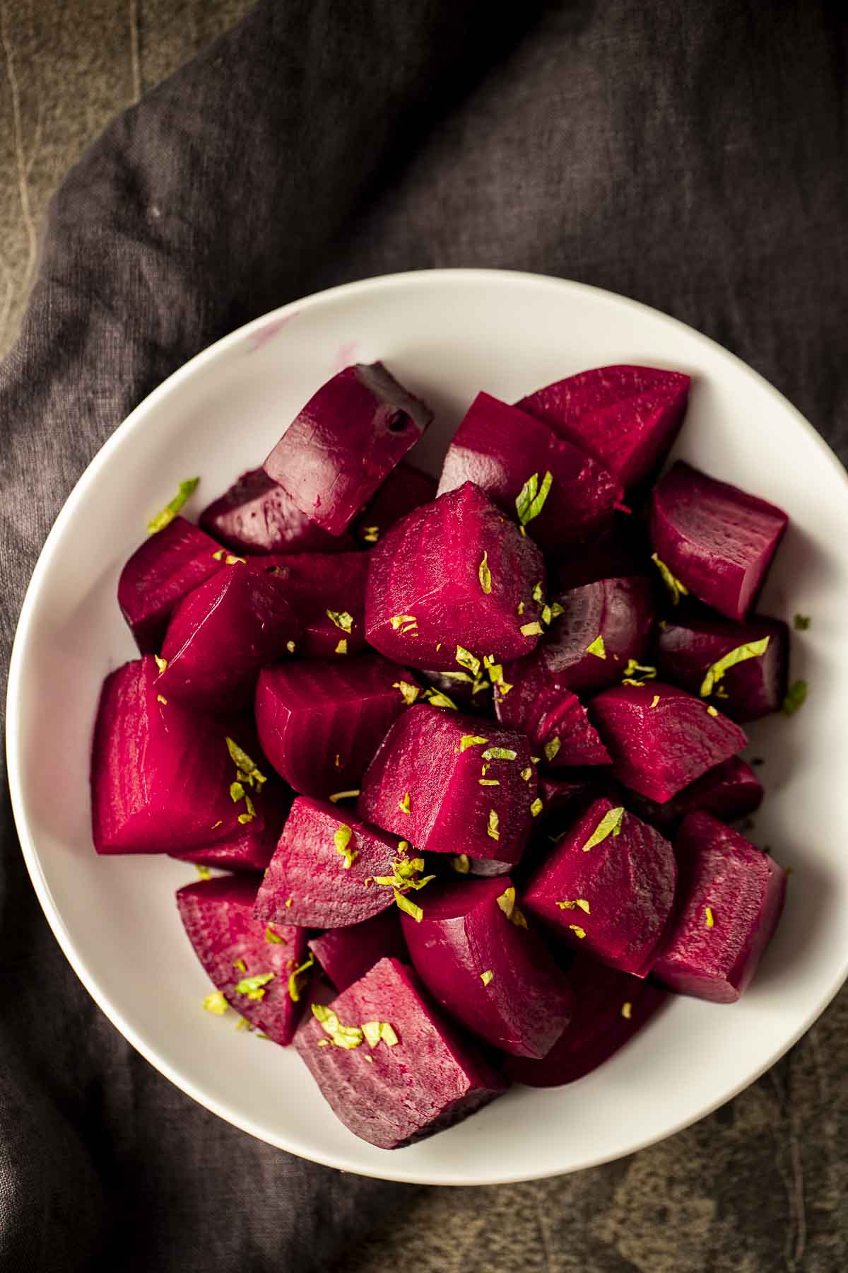 a bowl of cooked, chopped beets garnished with basil