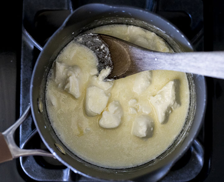 cream cheese pieces being melted in a saucepan
