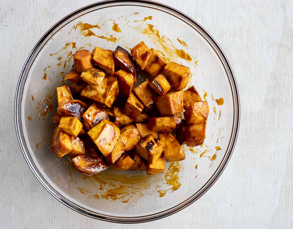 cubed sweet potatoes in a bowl coated in brown sauce