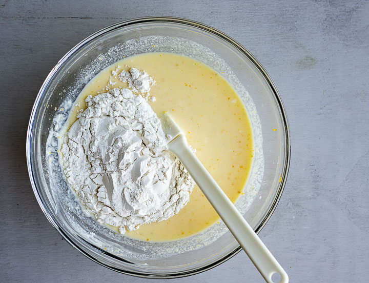 yellow batter being mixed with flour