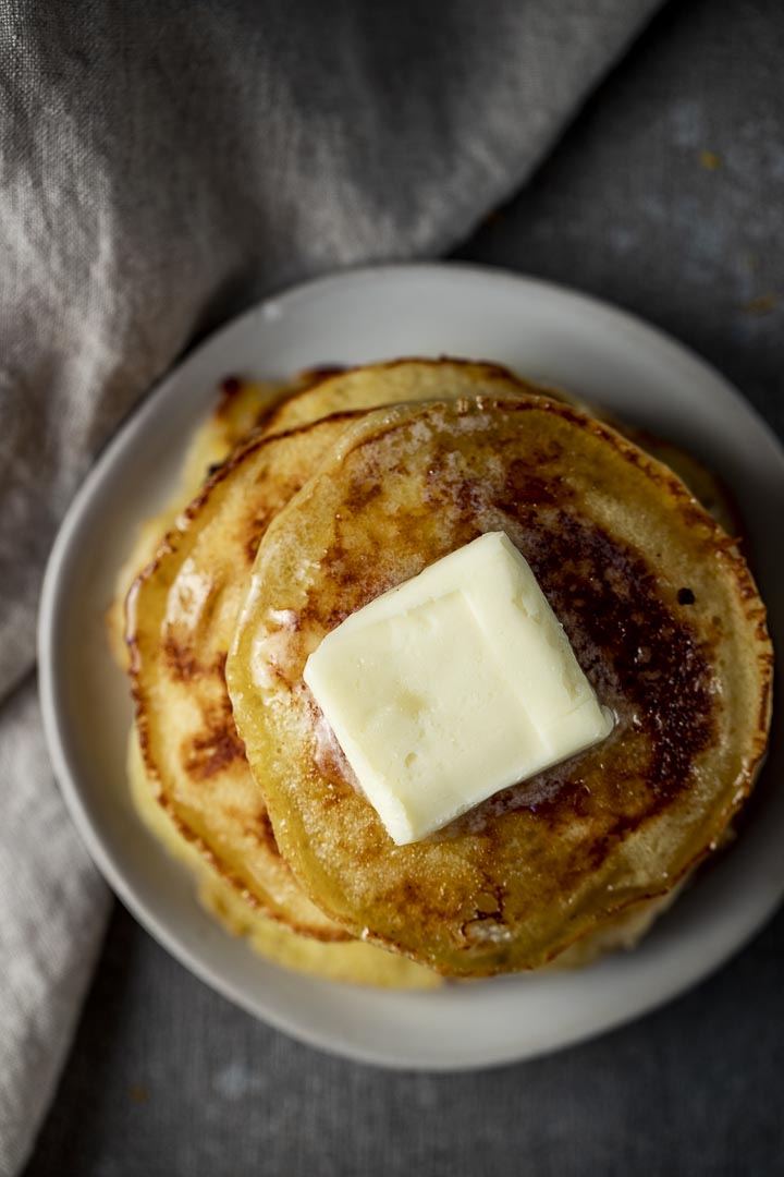 stack on pancakes on a plate with a piece of butter on top
