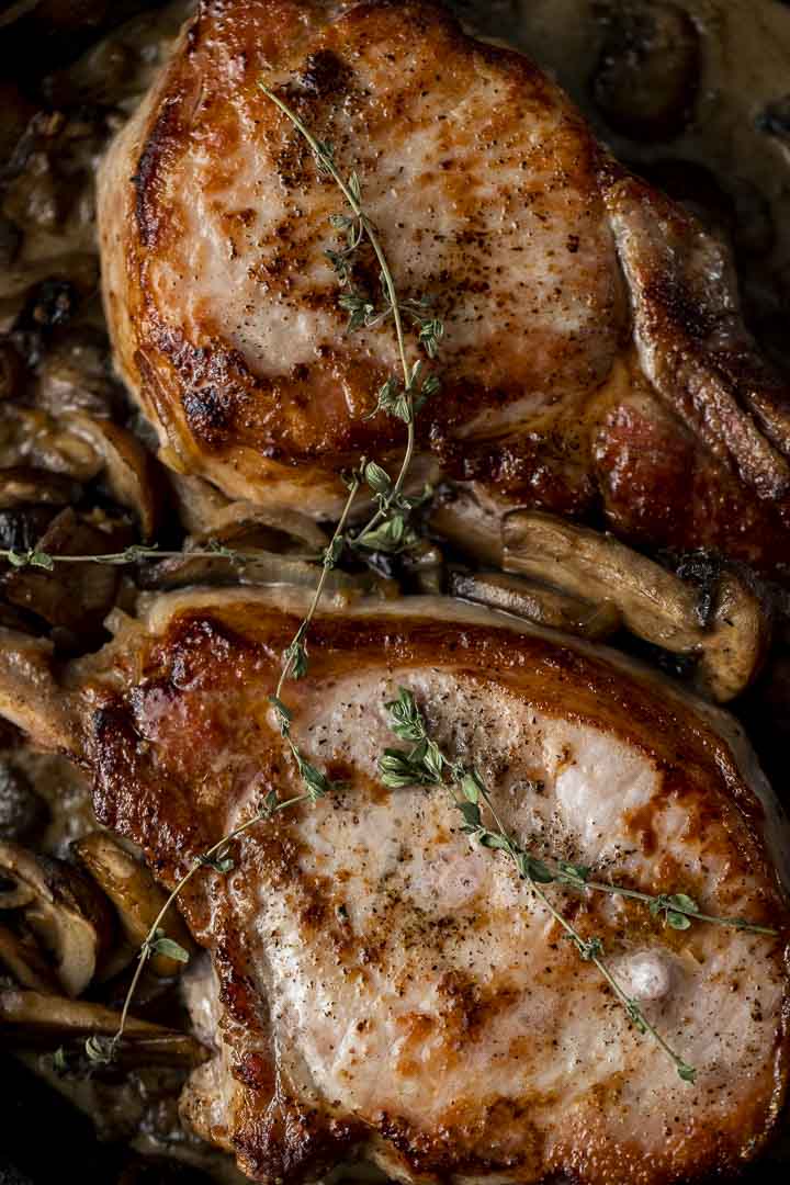 pork chops garnished with thyme and mushroom sauce