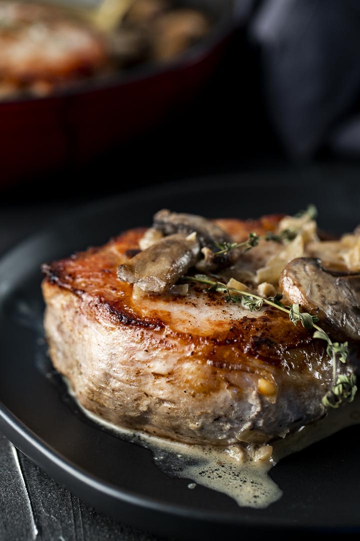 side view of a cooked pork chop with mushrooms on top