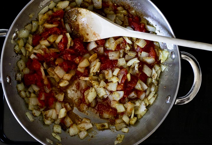 onions and tomatoes in a skillet with spices