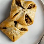 2 pastries filled with ground meat on a plate