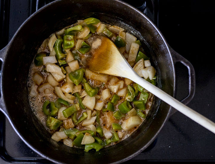 onions and green peppers cooking in roux in a pot