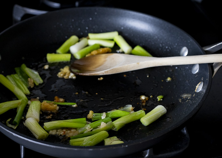 green onions and minced garlic frying in a skillet