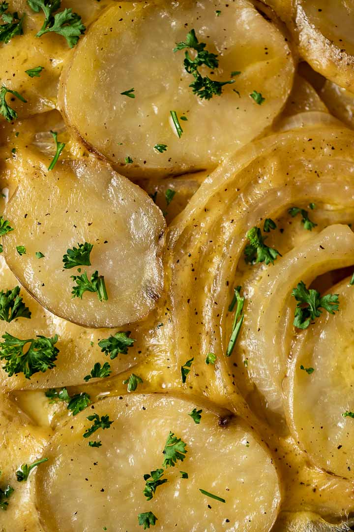 cheesy potatoes and sliced onions garnished with parsley