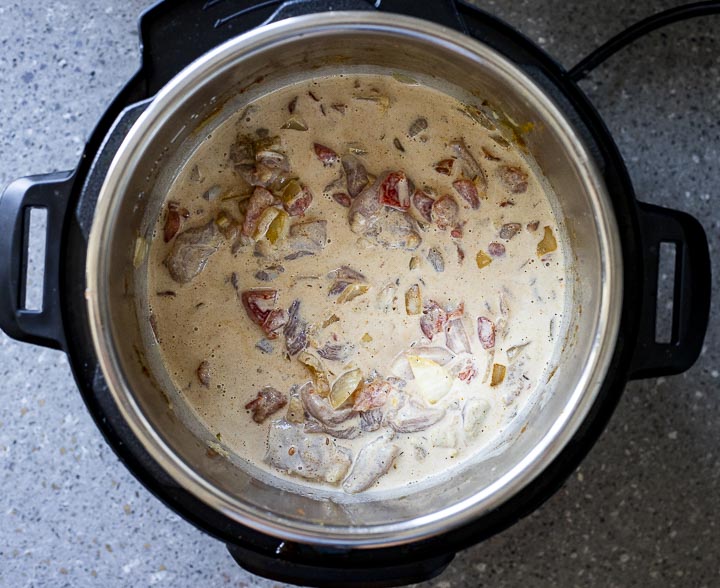 white creamy sauce in a pot with chicken and vegetbales