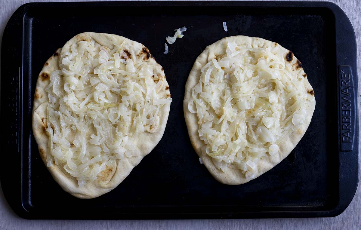 2 pieces of naan bread covered in cooked onions