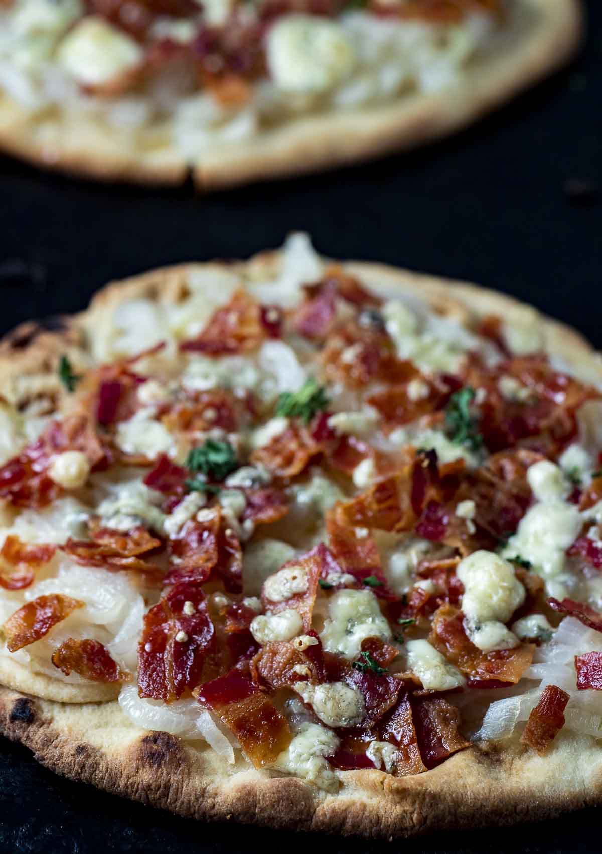 side view of flatbread pizza with onions and bacon