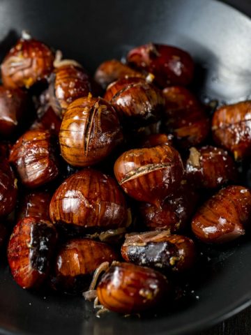 roasted chestnuts in a bowl with shallots and orange zest