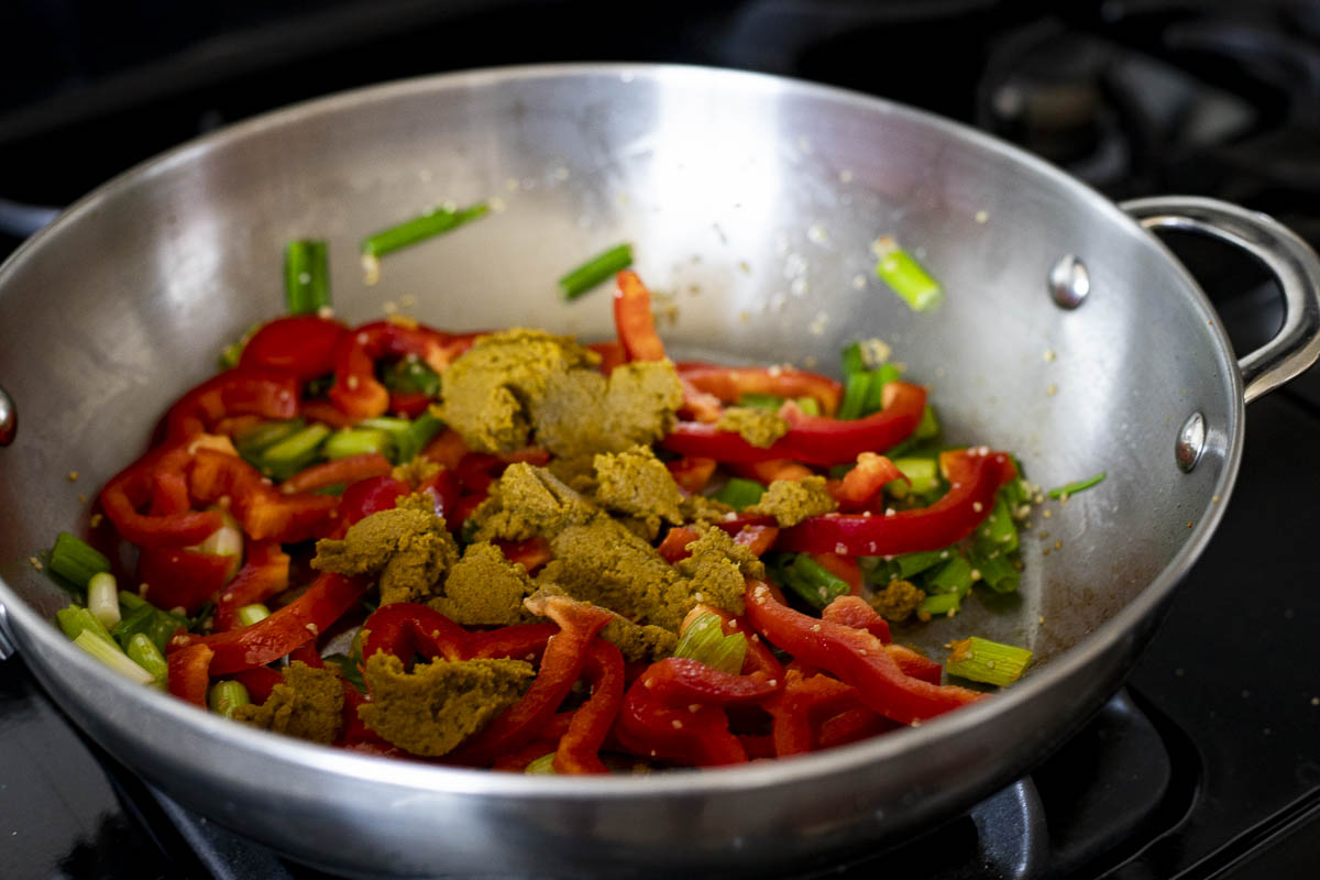 red peppers and green curry paste in a skillet