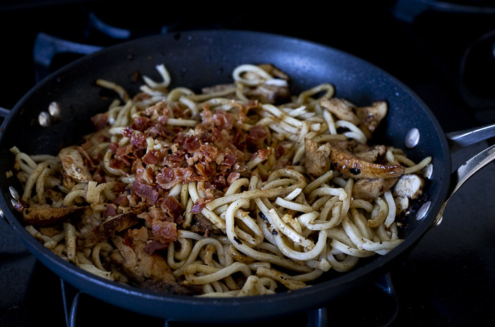noodles and bacon cooking in a skillet