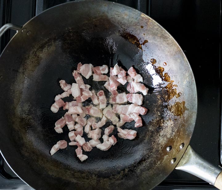 diced pork frying in a wok