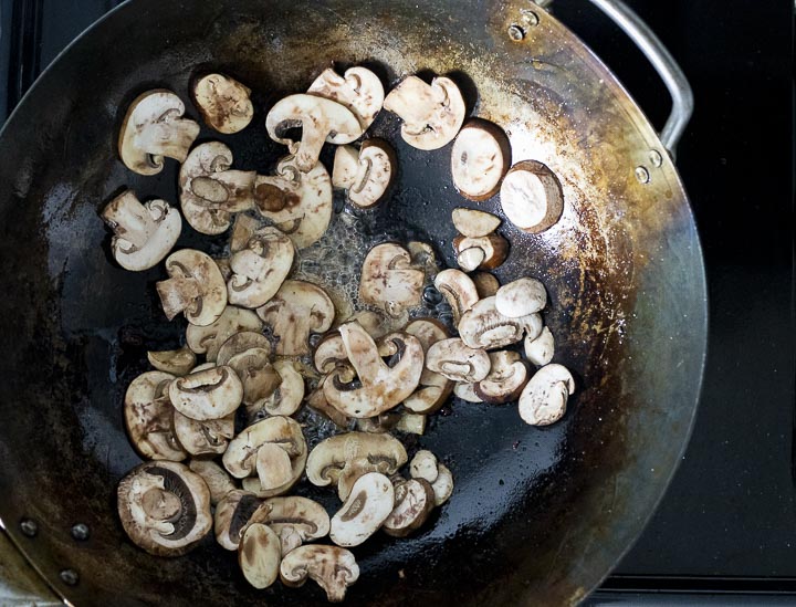 mushrooms frying in a wok